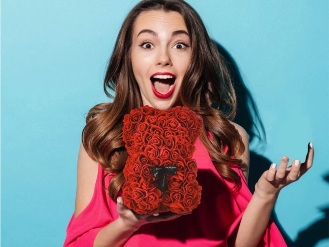 Ourson en pétales de roses dans une boîte cadeau