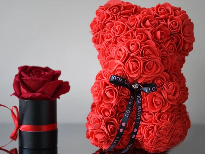 Ourson en pétales de roses dans une boîte cadeau
