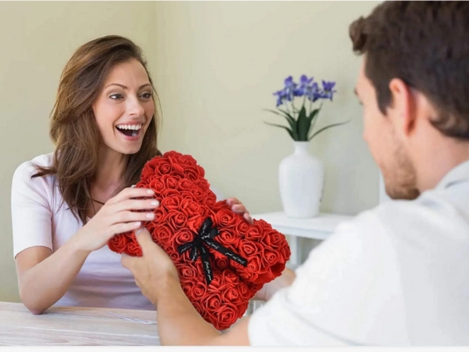 Ourson en pétales de roses dans une boîte cadeau