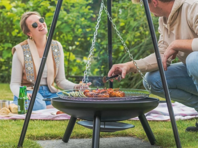 Grote tuinbarbecue met standaard op driepoot en hangende grill rooster